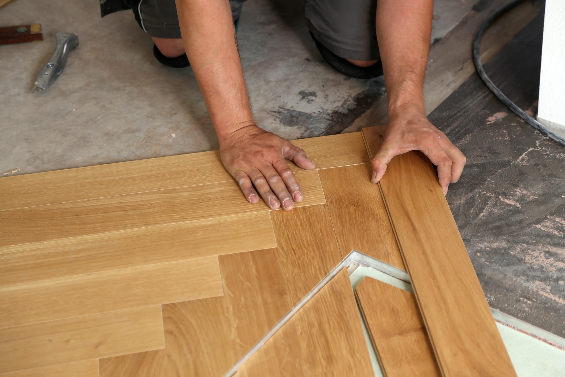 Worker laying parquet flooring. Worker installing wooden laminate flooring